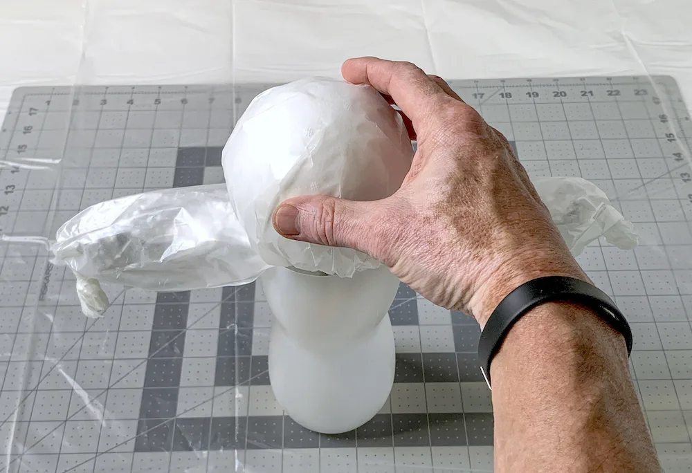 Hand placing a ball on top of the ghost mold