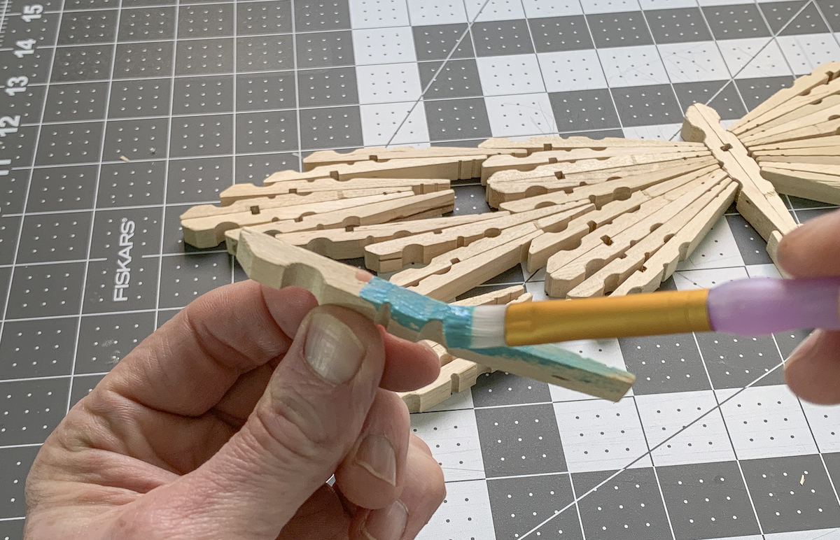 Painting clothespins with blue acrylic paint