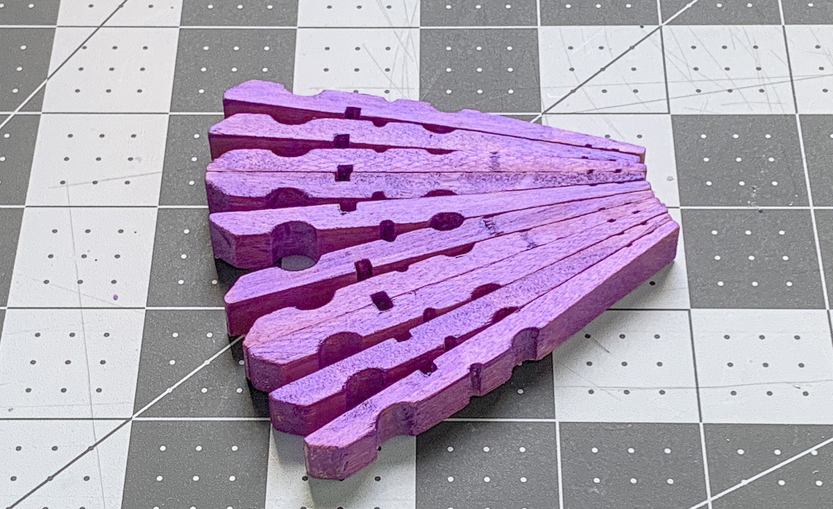 Purple painted clothespins shaped like a dragonfly wing