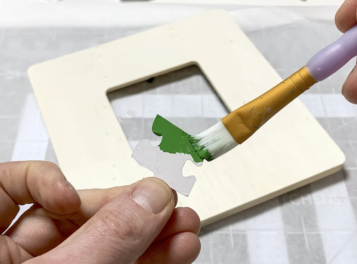 Painting a puzzle piece with green paint