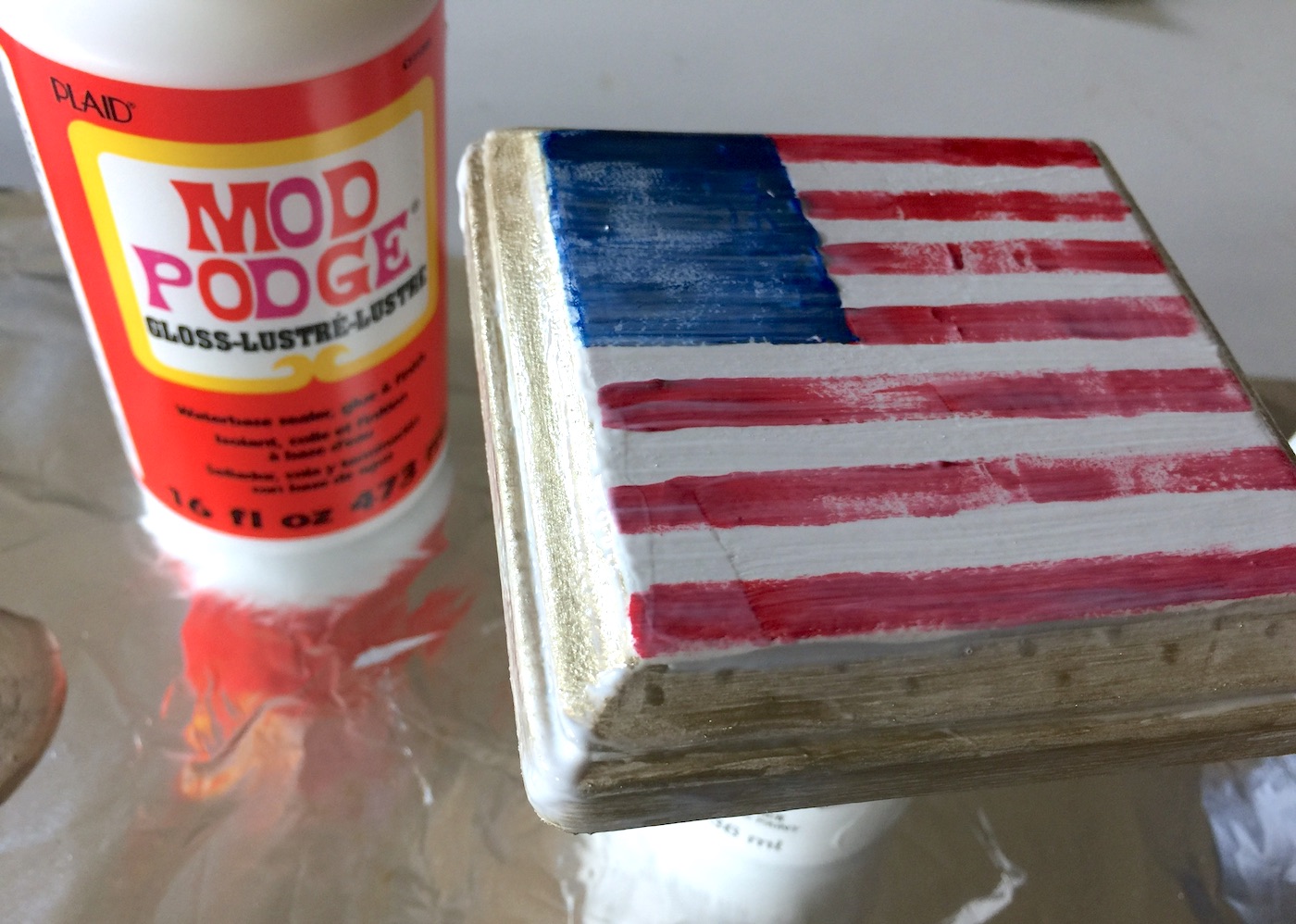 Layer of gloss Mod Podge on top of a rustic painted American flag