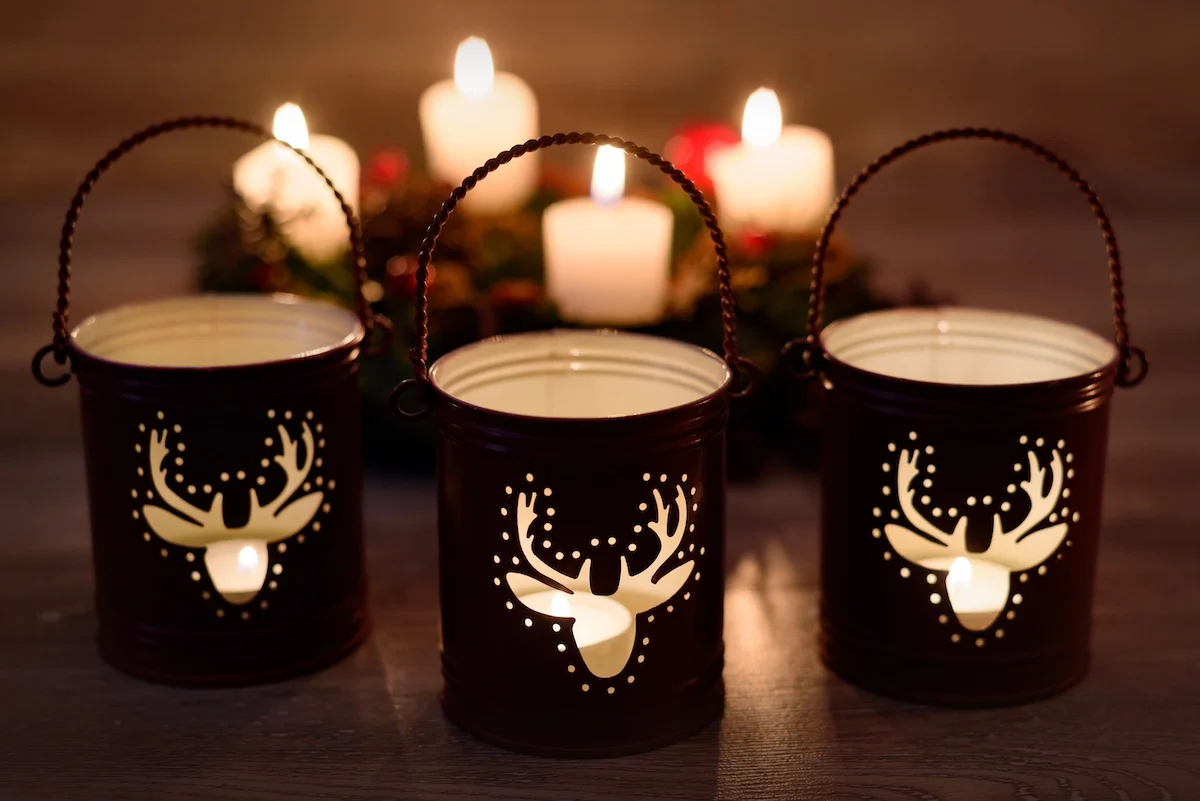 Christmas candle holders with pine cones on wooden background