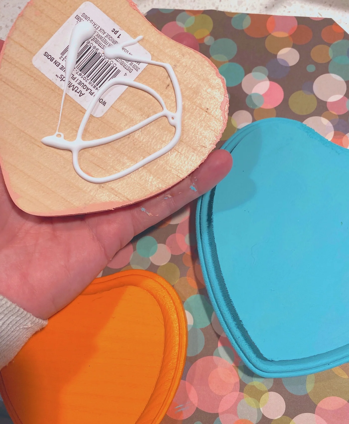 Gluing the wood hearts to the plaque with craft glue