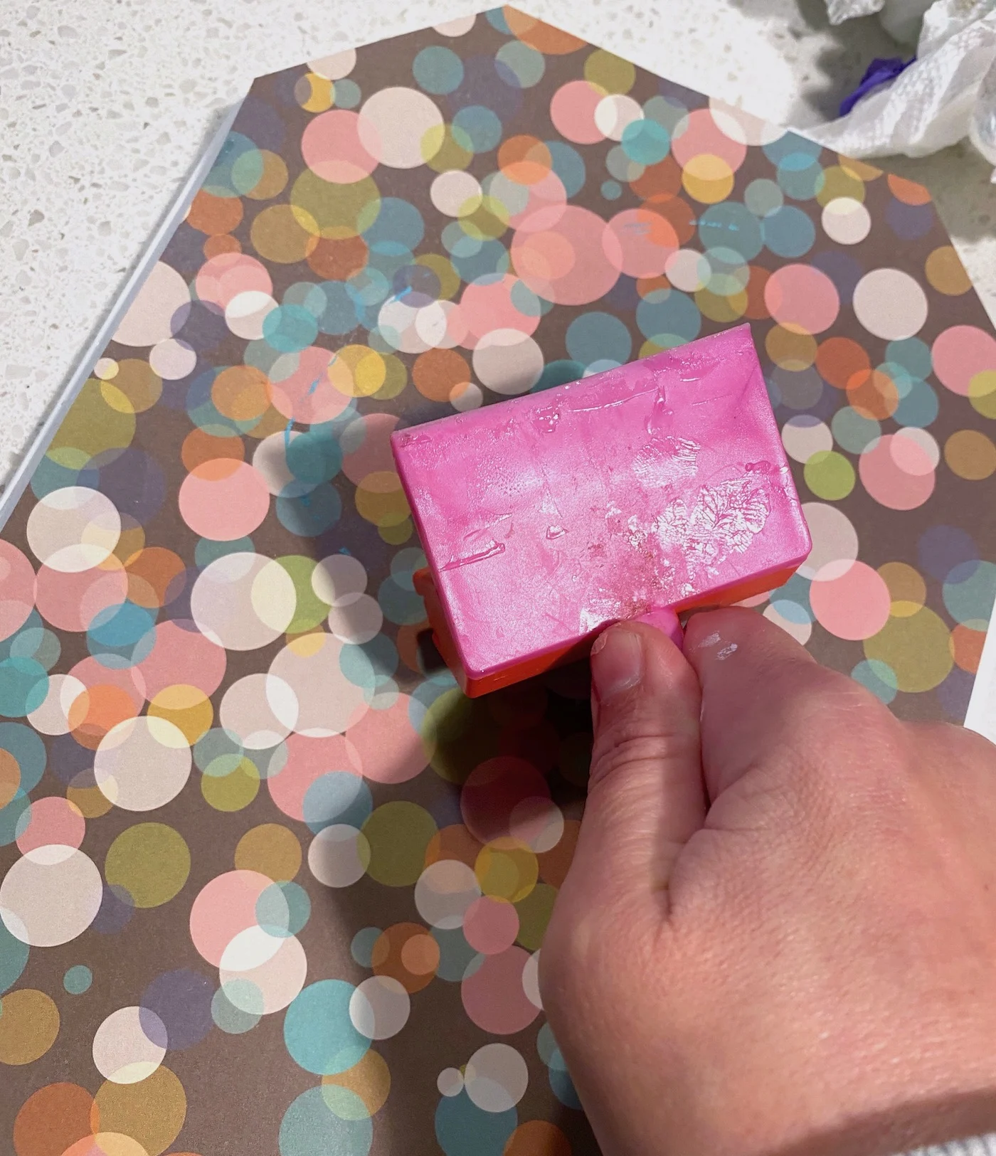 Using a brayer to roll the bubbles out of the scrapbook paper