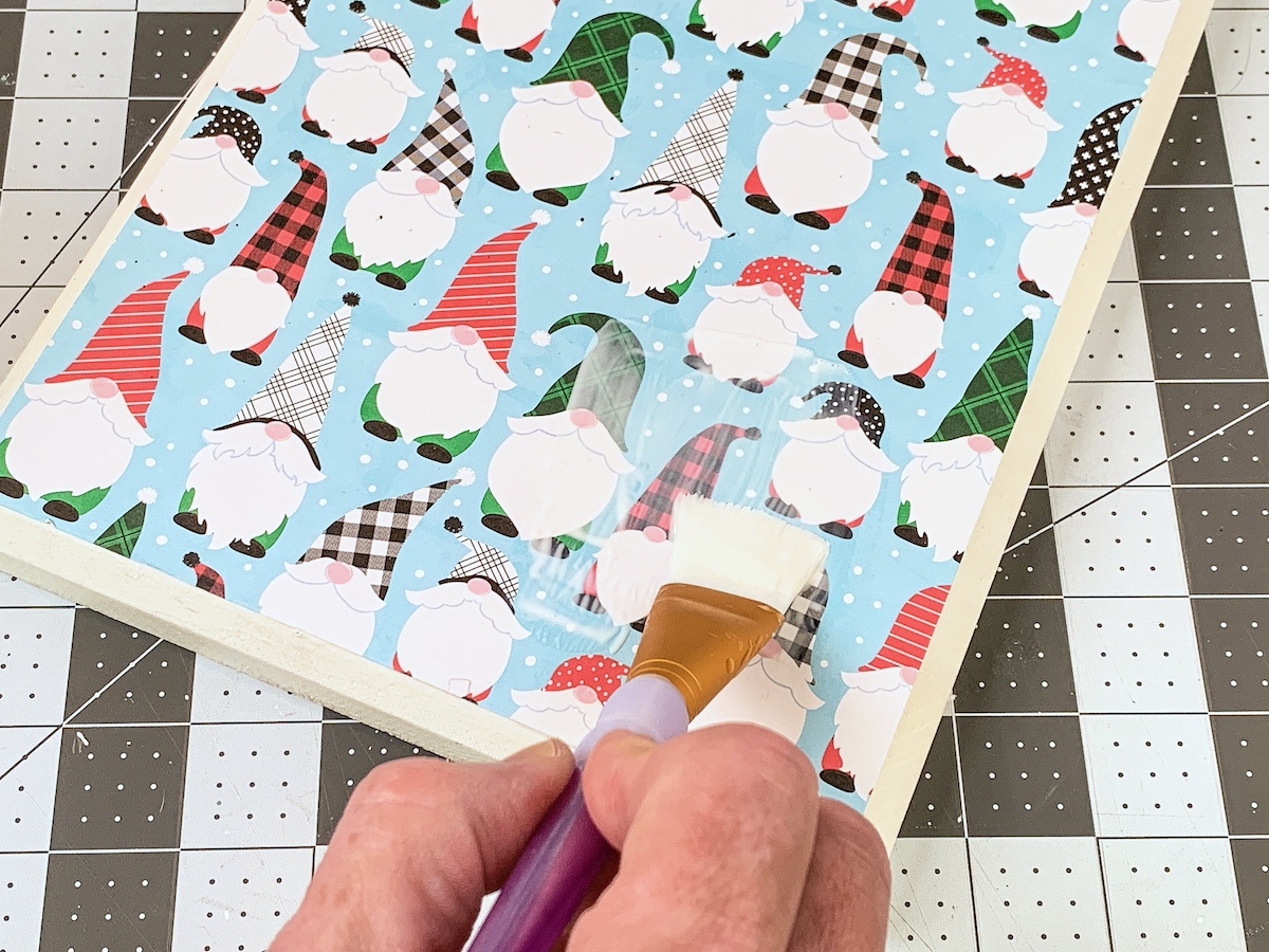 Apply Mod Podge over the top of the scrapbook paper and let dry