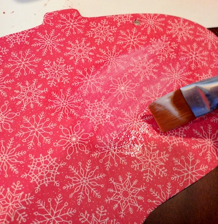 Applying a top coat over the top of the christmas tissue paper