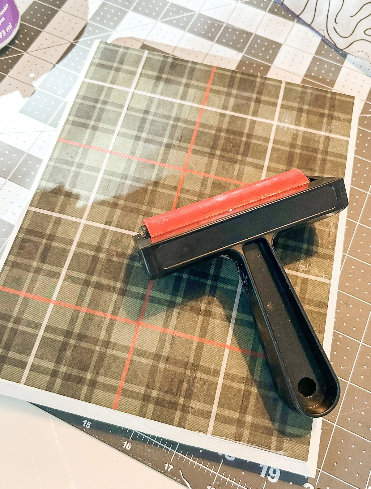 Brayer sitting on top of plaid paper