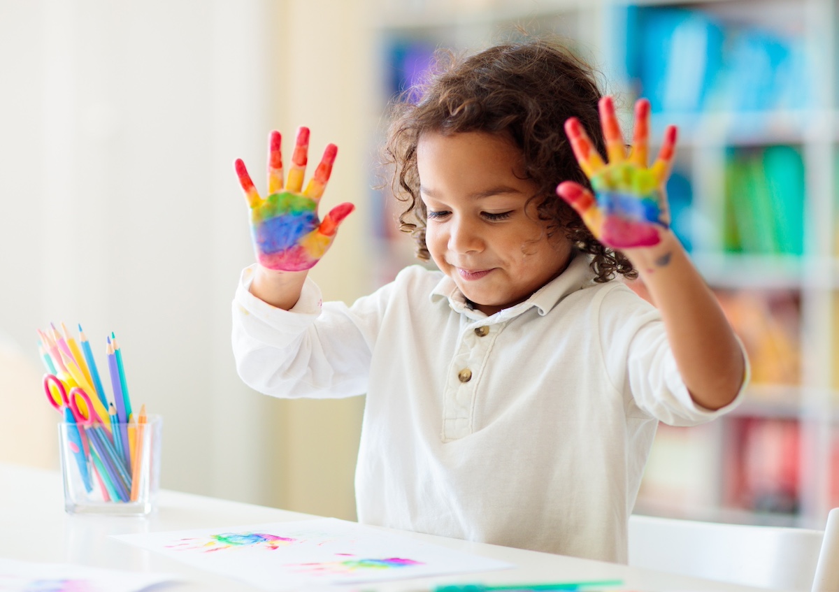 Child-holding-up-her-hands-painted-like-rainbows