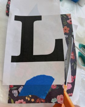 Cutting a letter out of paper using scissors