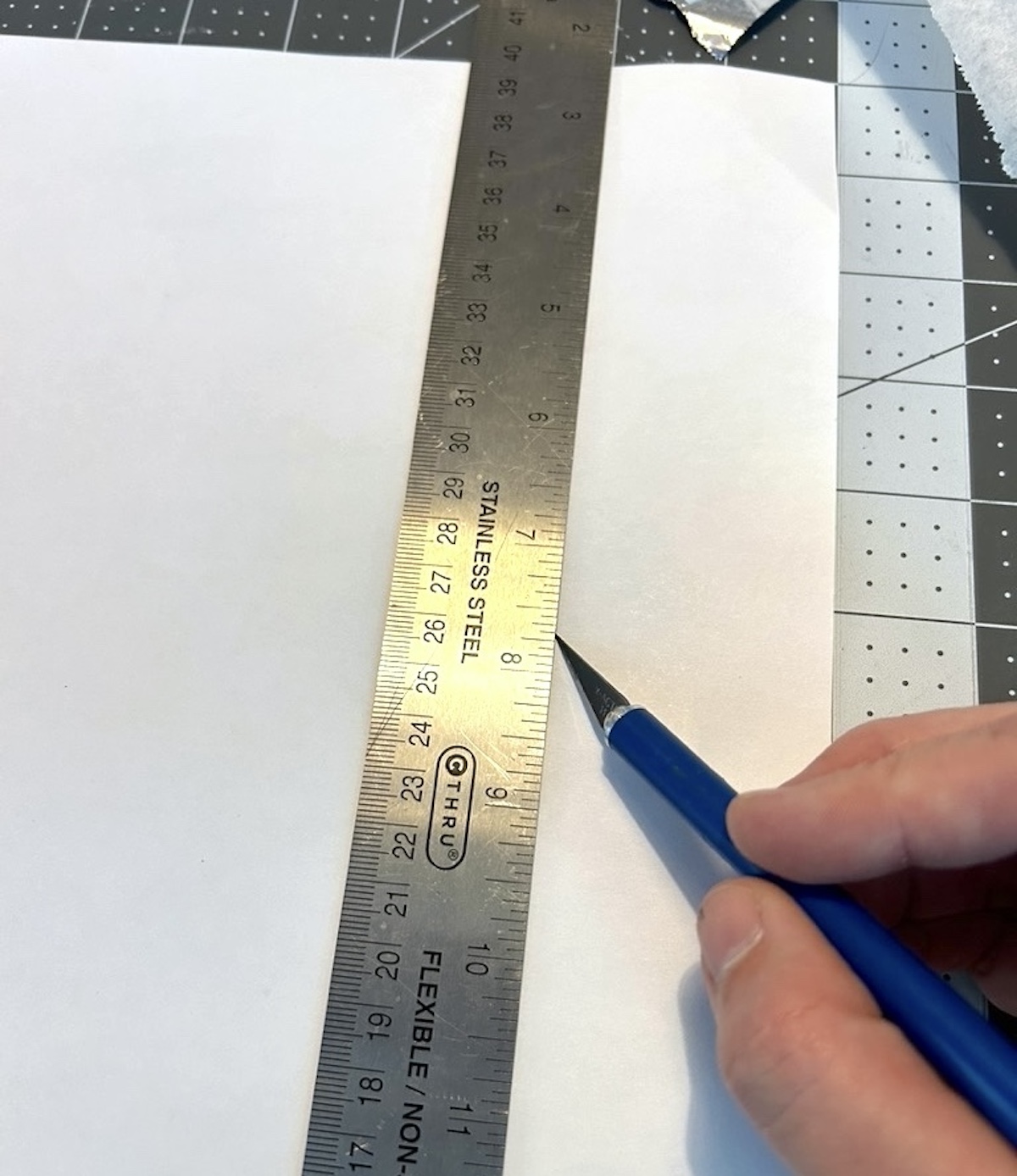 Cutting plaid paper with a craft knife, ruler, and mat