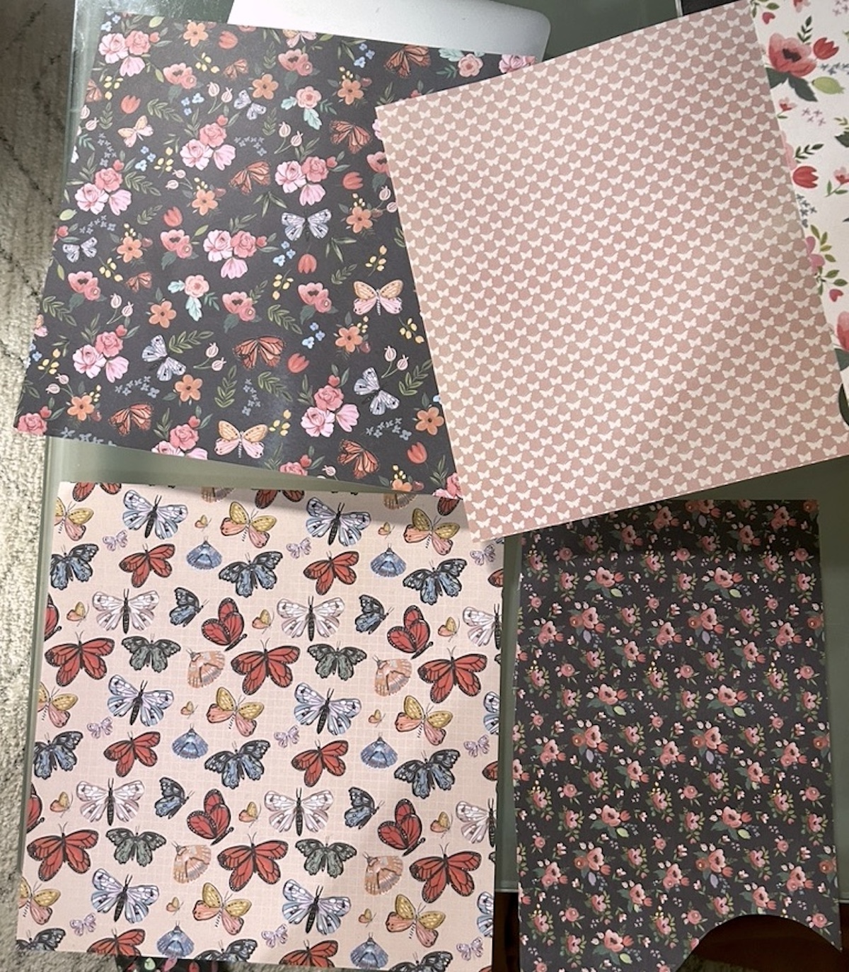Four sheets of scrapbook paper laid out on a table