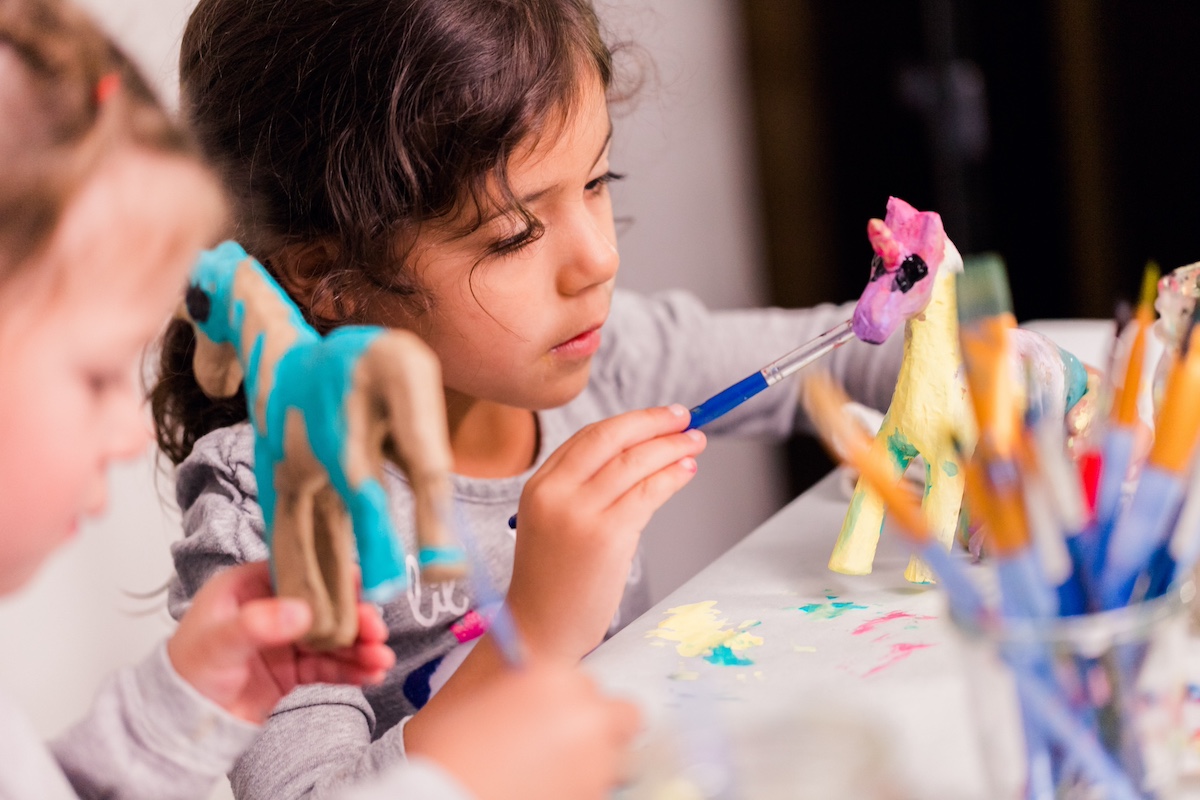 Little-kids-painting-paper-mache-horses-with-acrylic-paint