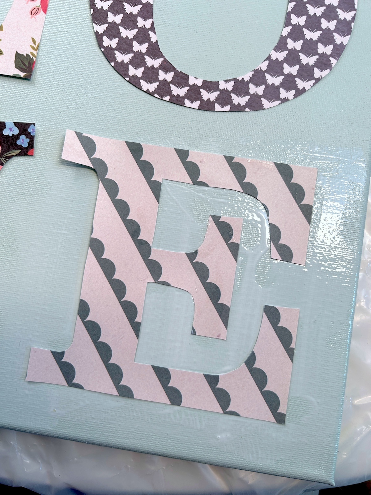 Smoothing the letter E down in wet Mod Podge