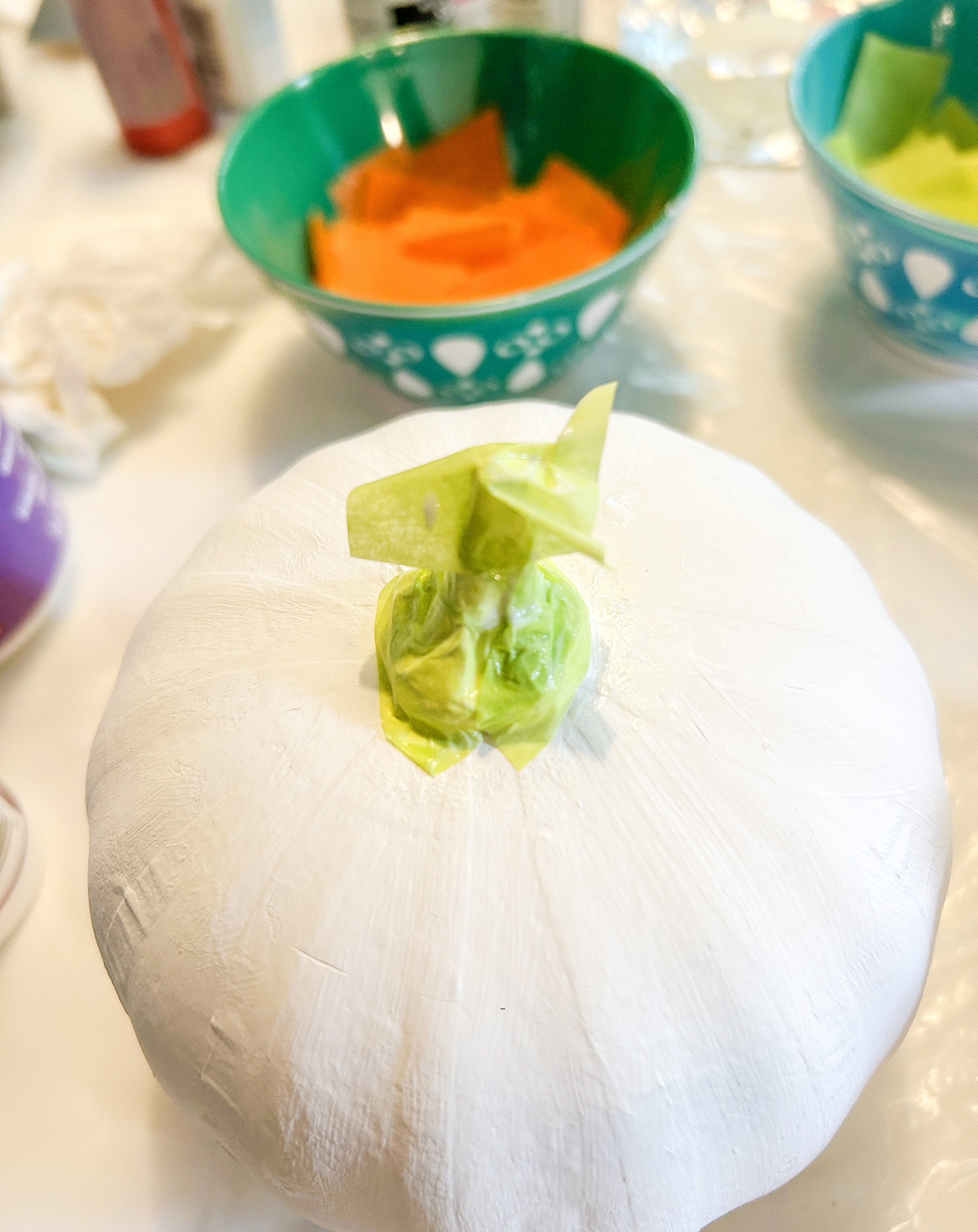 Covering the paper craft pumpkin stem in green tissue paper