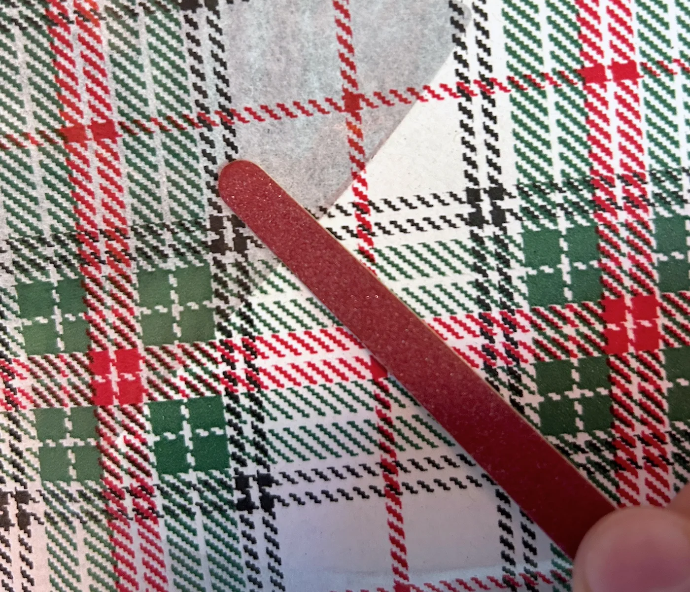 Filing the edge of a plaid napkin with an emery board
