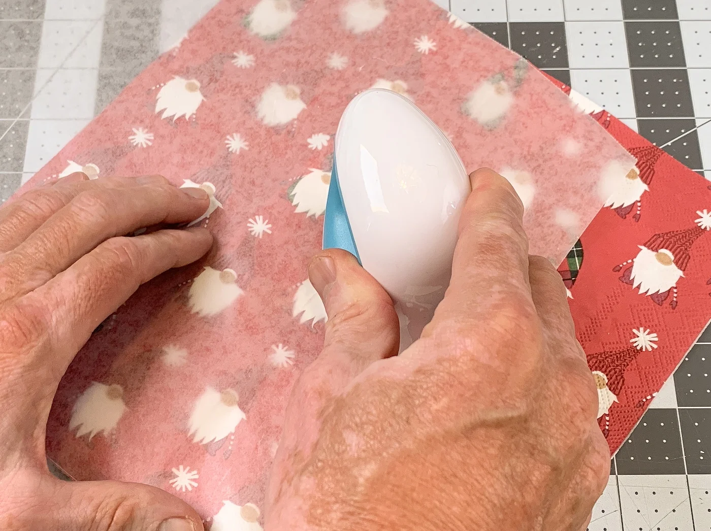 Ironing a christmas napkin onto unfinished wood using an iron and parchment paper