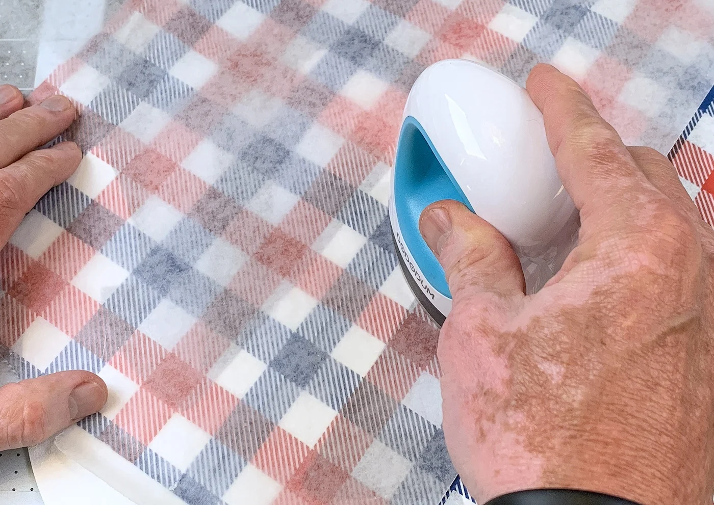 Ironing the red and blue plaid napkin into the boat wheel