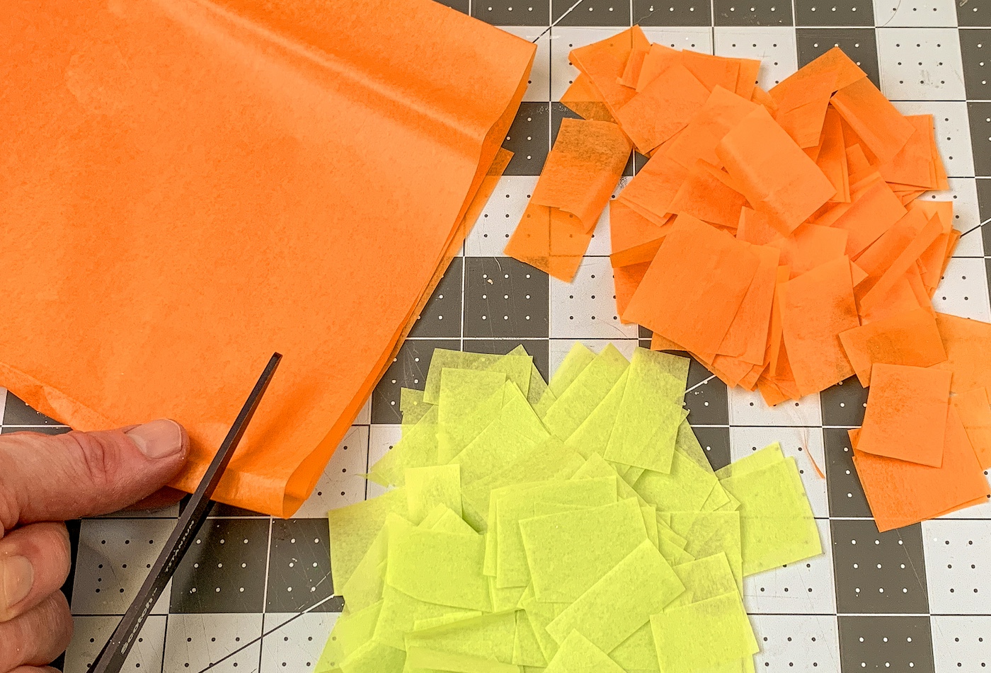 Orange and green tissue paper cut into squares
