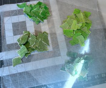 green painted book pages torn into pieces