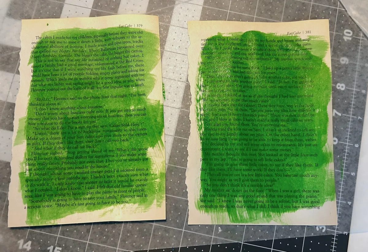 two book pages painted with a bright green paint wash