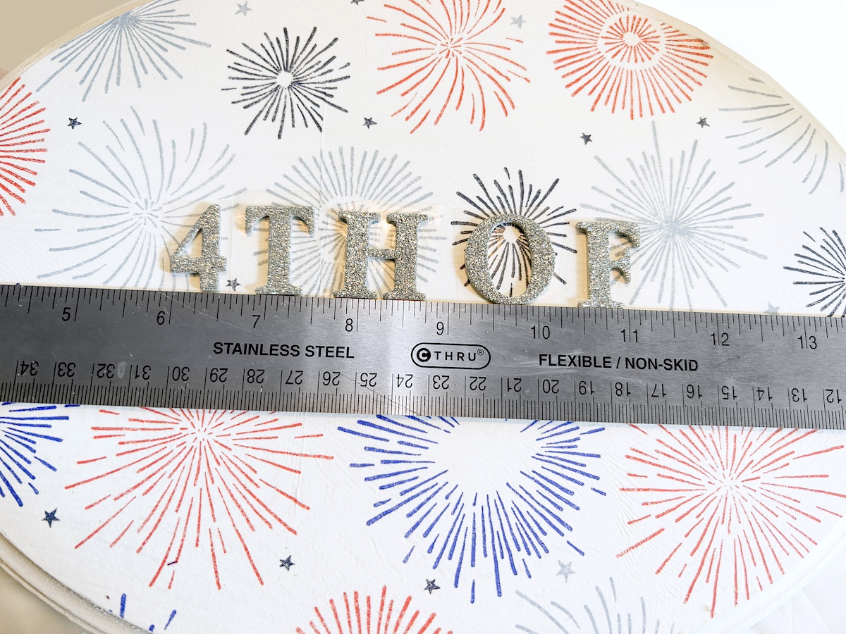 Add the silver glitter stickers to the wood plaque spelling Happy 4th of July