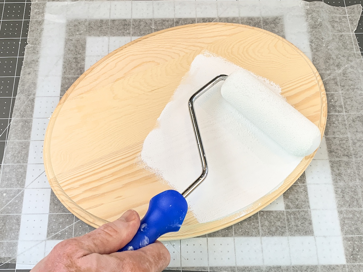 Painting a wood plaque with white paint using a foam roller