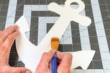 Painting two layers of Mod Podge on a painted wood anchor