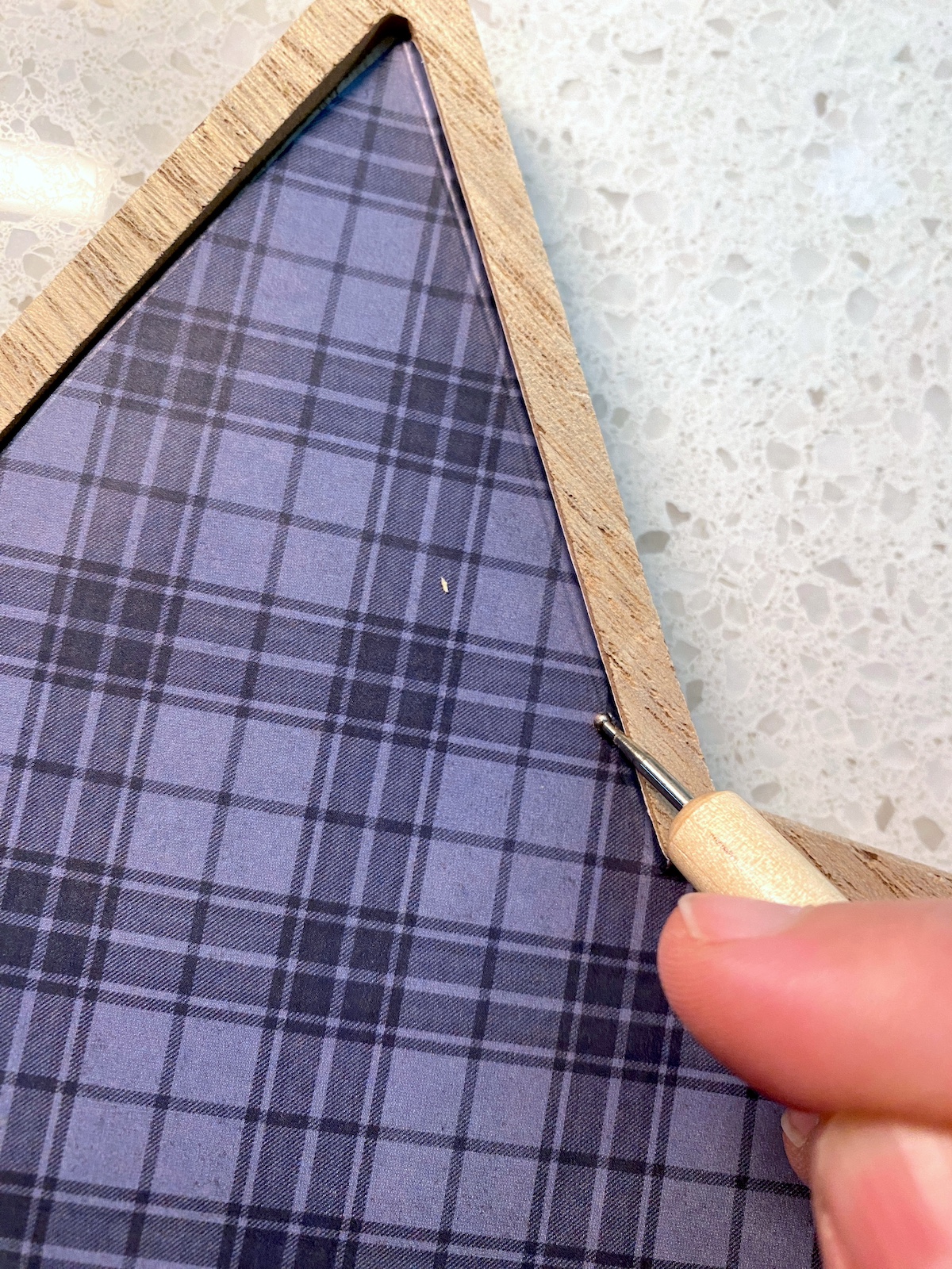 Pressing the plaid scrapbook paper into the corners of the star