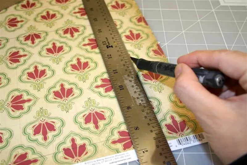 Cutting the Christmas paper with a ruler and craft knife