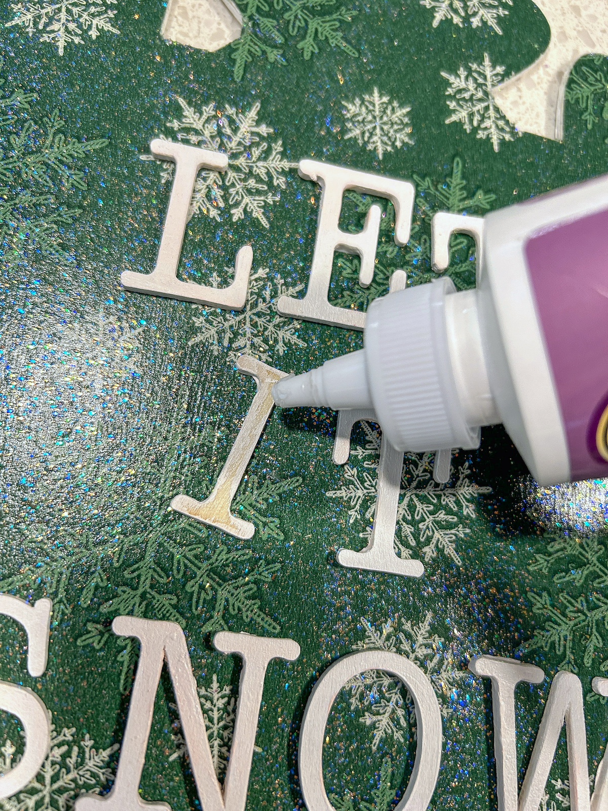 Gluing the let it snow wood letters down with craft glue