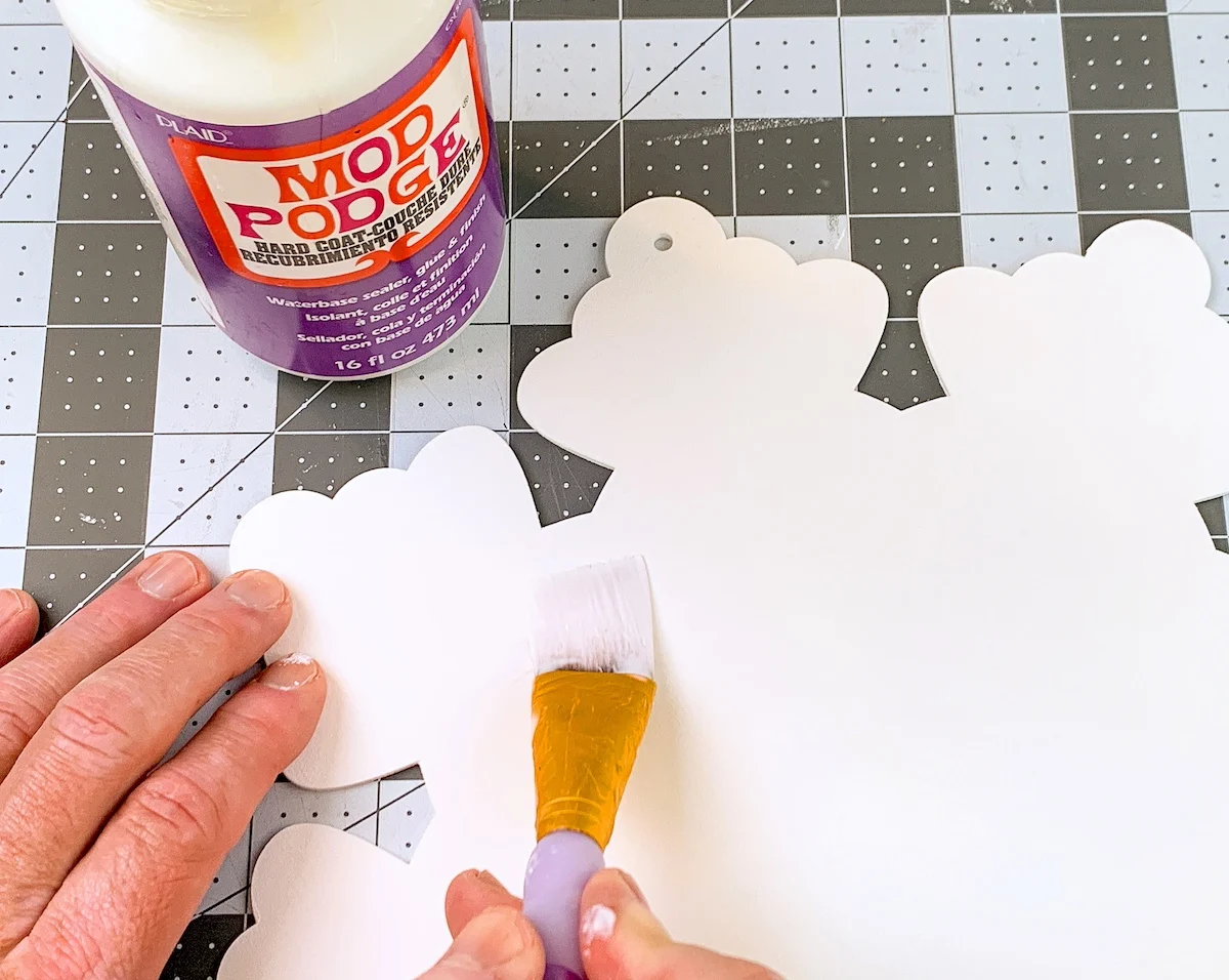 Painting the wood snowflake with Mod Podge