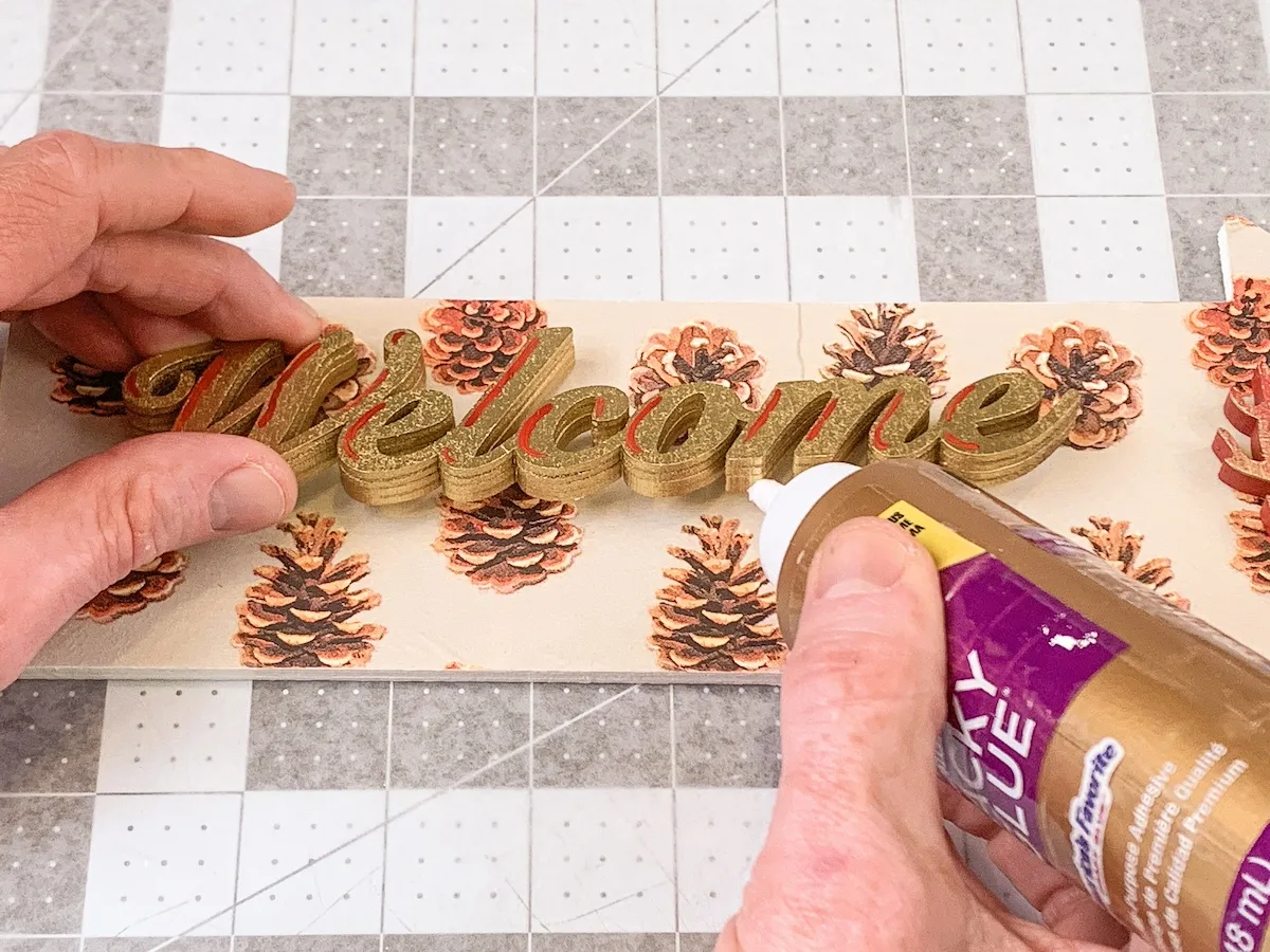 gluing the word welcome down with glue