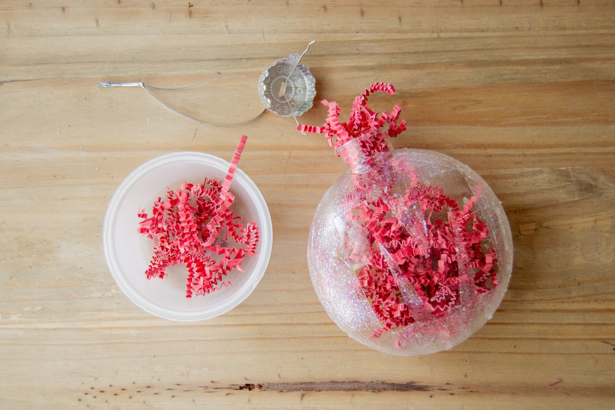 Filling the clear glass ornament with paper shreds