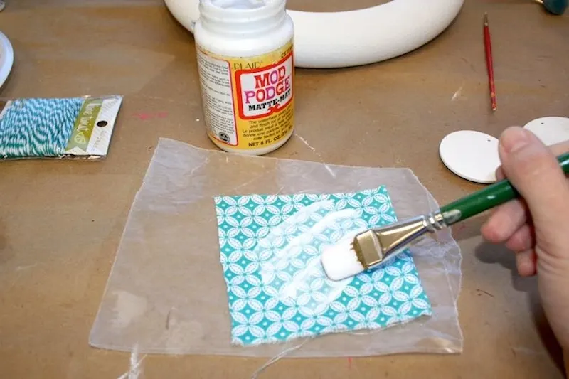 Painting fabric on wax paper with Mod Podge
