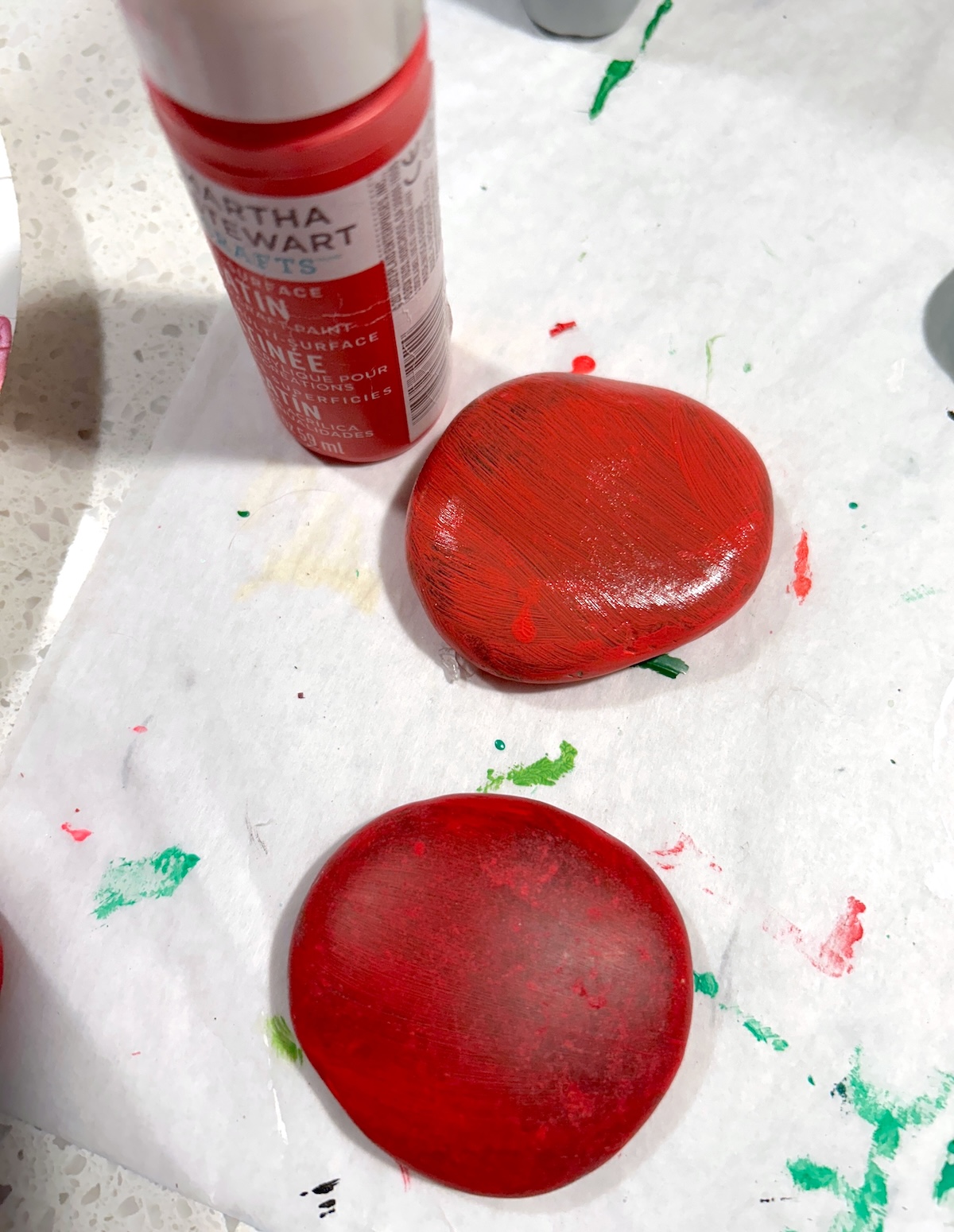 Painting round rocks with red paint
