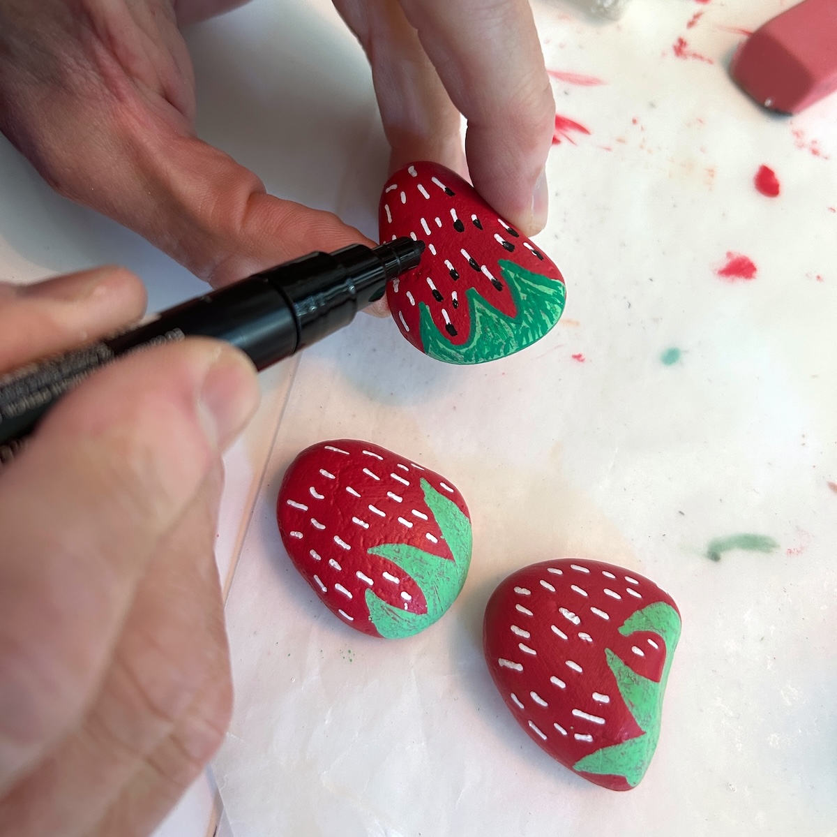 painting achenes on strawberry rocks with a paint pen