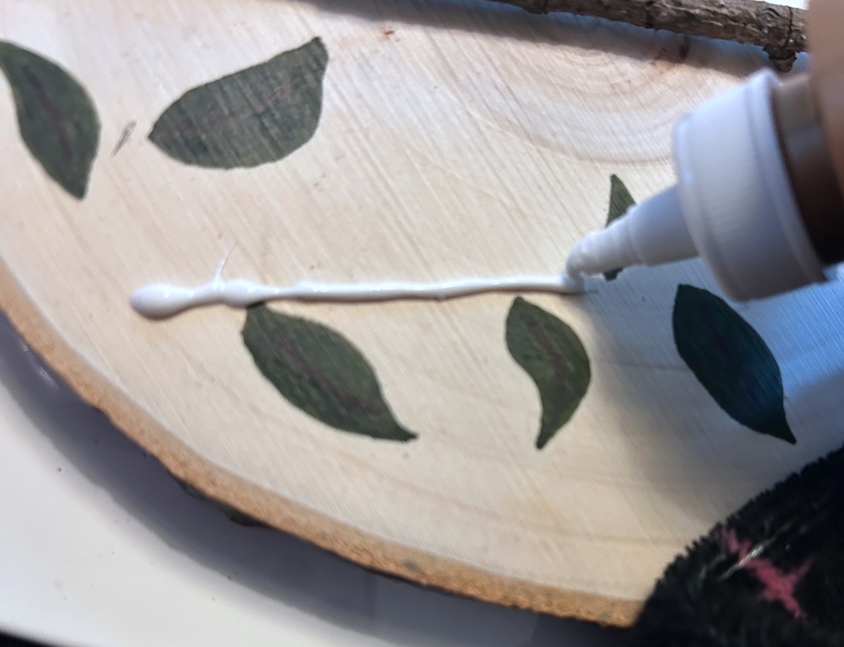 adding a line of glue to the wood circle